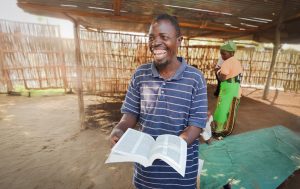 Man smiling with open Bible - Malawi, Harvesters Ministries and Biblica