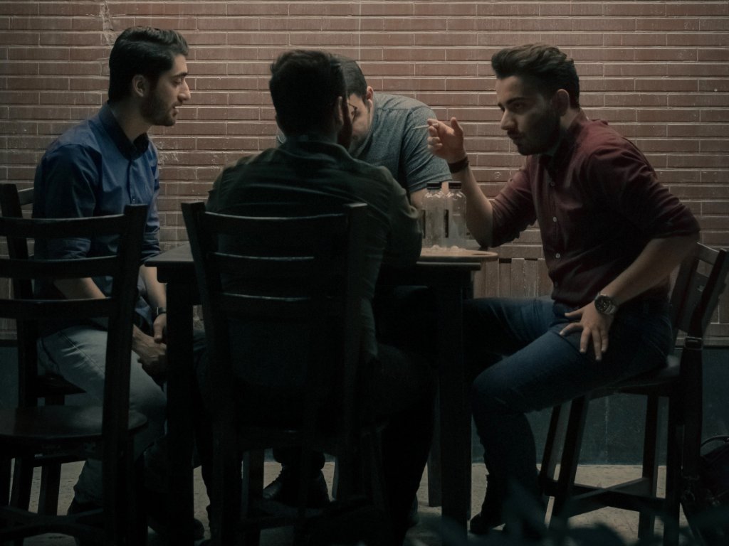four men chat in a cafe